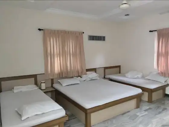 Family room with multiple beds at Trilok Darshan Dharamshala, Palitana