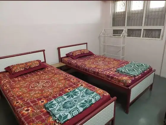 Group room with several beds at Trilok Darshan Dharamshala, Palitana